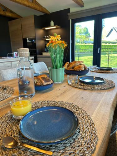 a wooden table with plates of food on it at La Roanneuse - Cosy Chalet in Francorchamps