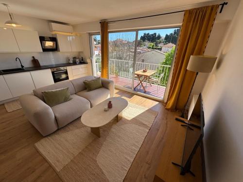 un salon avec un canapé et une table dans l'établissement Les Calanques d'Or - Apt Standing 4 Prs - Park - Clim, à Antibes