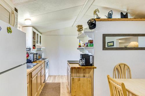 a kitchen with white walls and a table and a refrigerator at 2 Mi to World Equestrian Center Gem with Large Yard in Ocala