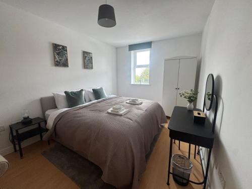 a white bedroom with a large bed and a window at 2 bed - 2 bath, gated parking, M62 J27 in Morley