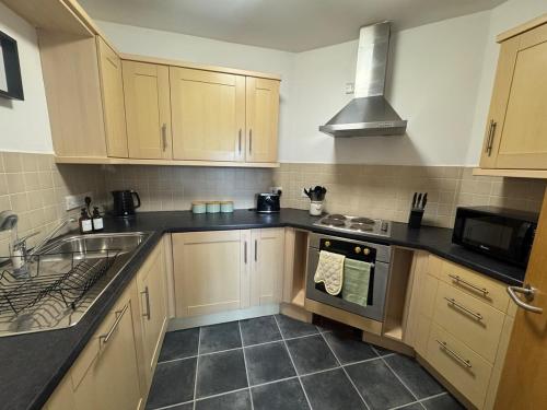 a kitchen with a sink and a stove top oven at 2 bed - 2 bath, gated parking, M62 J27 in Morley