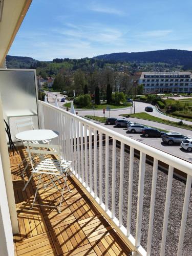 d'un balcon avec une table et des chaises offrant une vue sur la rue. dans l'établissement La parenthèse du lac, à Gérardmer