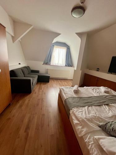 a bedroom with a bed and a couch at Hegyalja Fogadó in Sárospatak