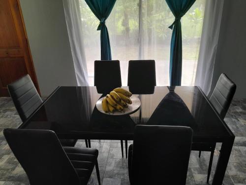 a dining room table with a plate of bananas on it at Va'a-va'a tea in Isla de Pascua