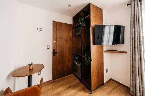 a living room with a table and a tv at Casa Castillo Condesa in Mexico City