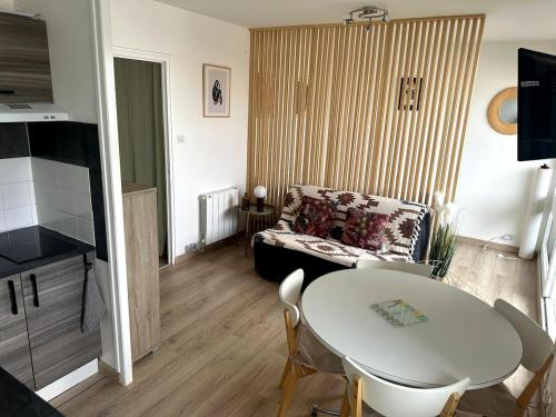 un salon avec une table et un canapé dans l'établissement Magnifique Vue à 2 pas de la plage, à Saint-Hilaire-de-Riez