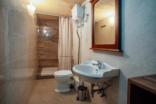 a bathroom with a sink and a toilet and a mirror at Senglea town house in Senglea