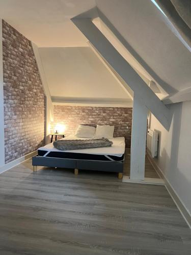 une chambre avec un lit dans un mur de briques dans l'établissement Maison Salignac 9 personnes, à Salignac Eyvigues