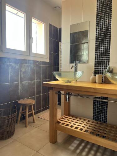 La salle de bains est pourvue d'un lavabo et d'un comptoir avec un tabouret. dans l'établissement Maison Salignac 9 personnes, à Salignac Eyvigues