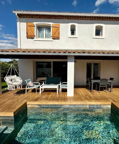 une maison avec une terrasse et une piscine dans l'établissement Villa avec piscine proche de la plage, à Pérols