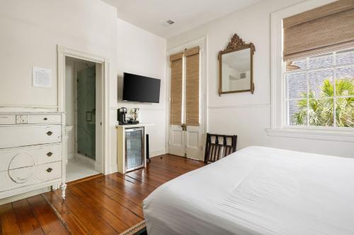 una camera da letto con un letto, una cassettiera e una televisione di The Ashley Veranda King Suite includes Breakfast a Charleston
