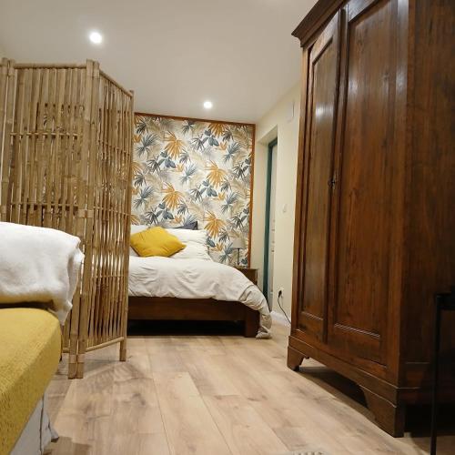 - une chambre avec un lit et une grande armoire en bois dans l'établissement Studio au cœur de la nature, à Saint-Paul-en-Born