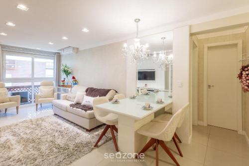 a living room with a table and a couch at Apto Aconchegante no Centro de Canela | CPL025 in Canela