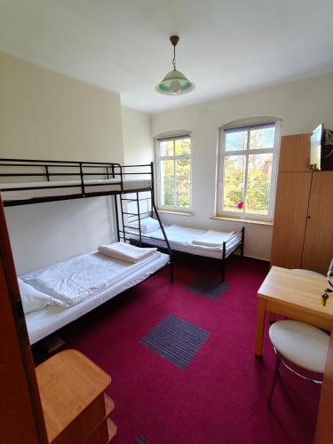 a room with two bunk beds and a desk at Wille Amber in Mielno