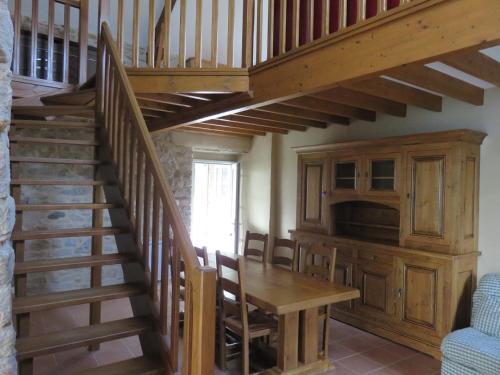 - un escalier en bois dans une chambre avec une table et une cuisine dans l'établissement La Pigacherie aux Pierres Bleues, à Surtainville