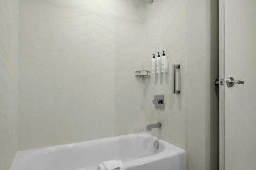 a white bathroom with a tub and a sink at Fairfield by Marriott Inn & Suites Kokomo in Kokomo