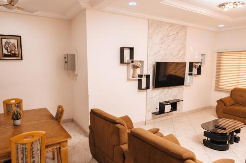a living room with a couch and a television on a wall at New 2Bed RealShala-Adjiringanor in Ashalebotwe