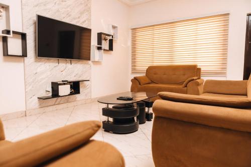 a living room with two chairs and a tv at New 2Bed RealShala-Adjiringanor in Ashalebotwe