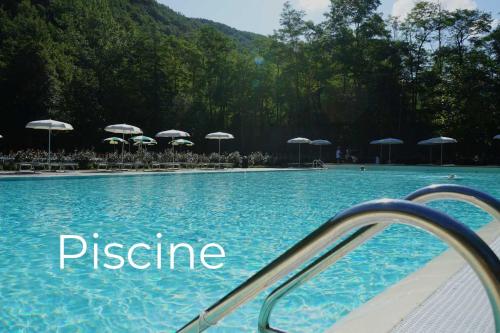 a swimming pool with chairs and umbrellas at Casarosa in Porretta Terme