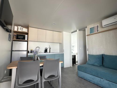 a kitchen and living room with a table and a couch at Mobile Homes Nina & Ena, Dalmata Camping Orebić in Orebić