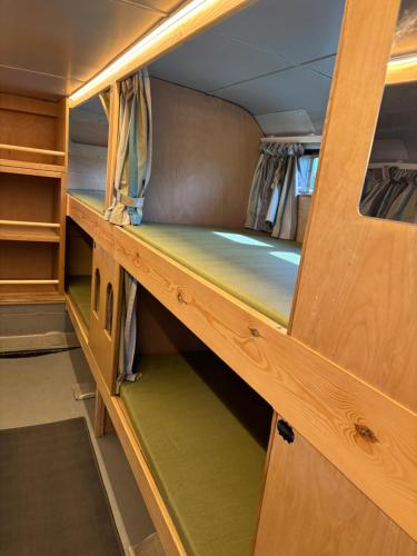 a room with two bunk beds in a train car at Cornwalls Vintage Camping Bus in Delabole