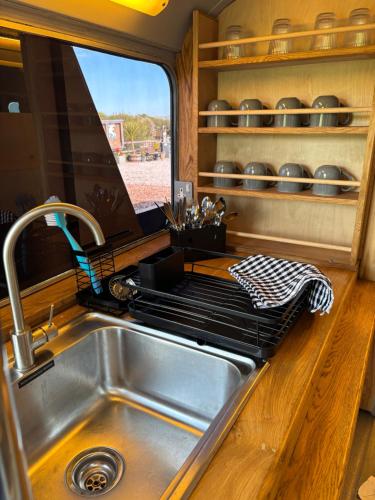 a kitchen with a sink and a counter top at Cornwalls Vintage Camping Bus in Delabole