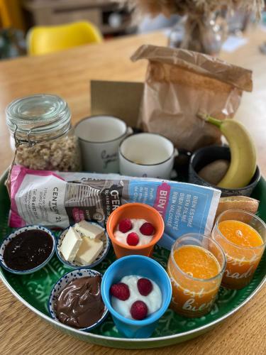 une assiette contenant différents types de denrées alimentaires sur une table dans l'établissement Nuit romantique avec jacuzzi privé !, à Noé