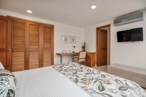 a bedroom with a bed and a desk and a television at Alcazar de Oviedo by EE Hoteles in Medellín