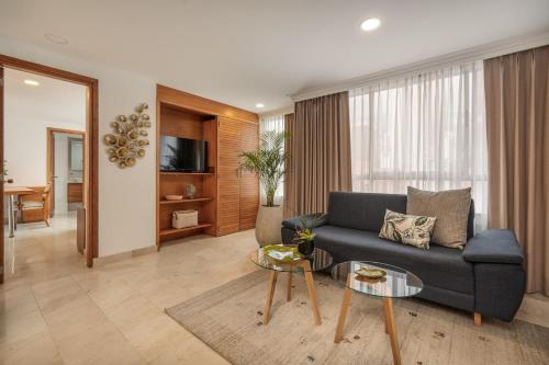 a living room with a couch and a table at Alcazar de Oviedo by EE Hoteles in Medellín
