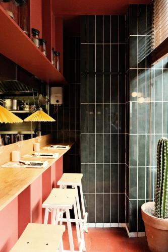 un restaurant avec un comptoir avec des tables et un cactus dans l'établissement Chez Georges - Auberge Contemporaine, à Lille