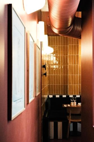 une salle de bain avec une table et quelques tableaux au mur dans l'établissement Chez Georges - Auberge Contemporaine, à Lille