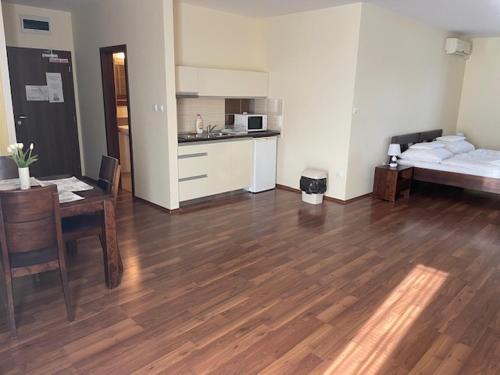 a room with a bed and a table and a kitchen at Mlyn Penzion & Wellness in Radvaň nad Dunajom