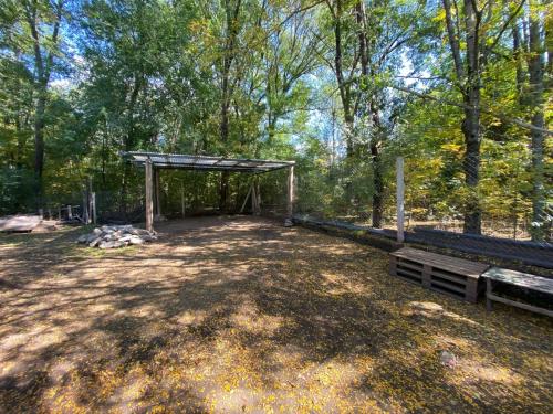 a picnic shelter in a park with two benches at Villa Simona in Santa Rosa de Calamuchita