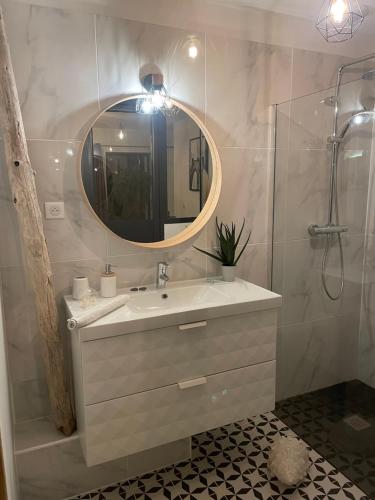 une salle de bain avec un lavabo et un miroir dans l'établissement Nuit romantique avec jacuzzi privé !, à Noé