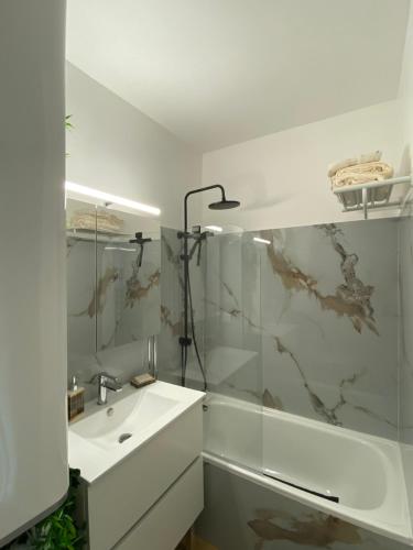 une salle de bain blanche avec un lavabo et une douche dans l'établissement Le Lagon Bleu, à Fréjus