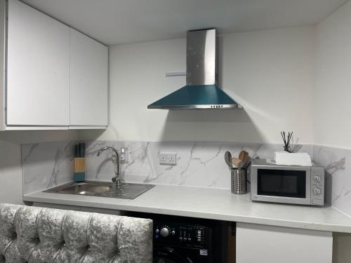 a kitchen with a microwave and a sink at Cozy mini studio in Basildon in Nevendon