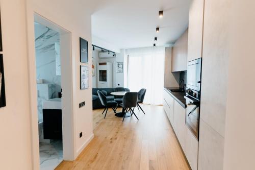a kitchen and living room with a table and chairs at Evo Residence Taietura Turcului in Cluj-Napoca