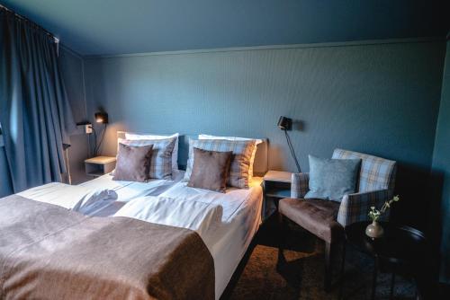 a hotel room with two beds and two chairs at Trolltun Hotel & Hytter in Dombås