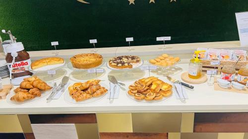a table with many different types of pastries and pies at Hotel Camelia in Cameri