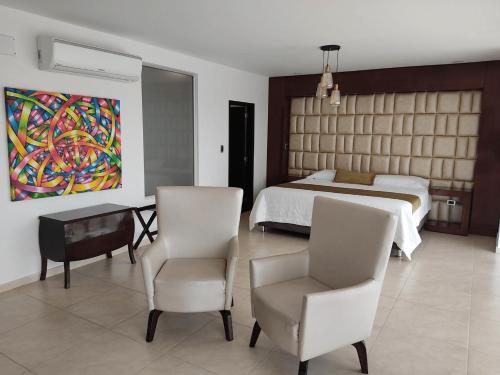 a bedroom with a bed and a table and chairs at Hotel Andinos Plaza Florencia in Florencia