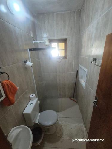 a small bathroom with a toilet and a shower at Kitão Completo ao lado da Balsa Bertioga in Bertioga