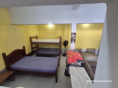 a room with two bunk beds and a couch at Kitão Completo ao lado da Balsa Bertioga in Bertioga