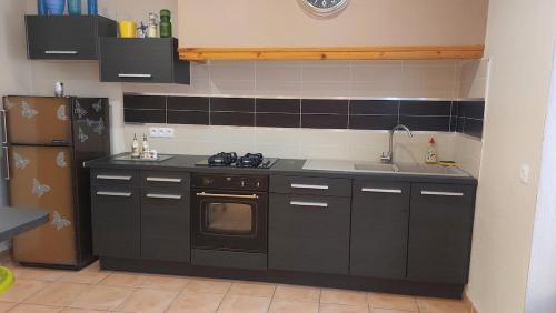 La cuisine est équipée d'une cuisinière, d'un évier et d'un réfrigérateur. dans l'établissement Charmant T2 à 5min des plages, à Port-la-Nouvelle