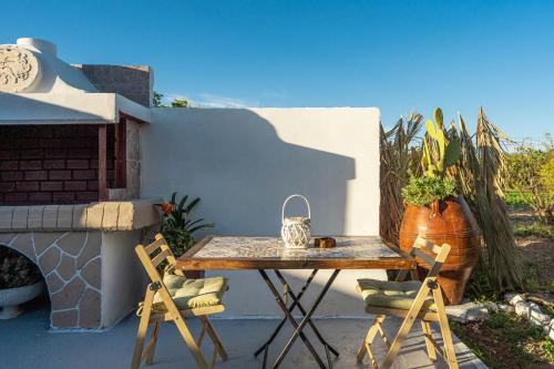 a table and two chairs on a patio at MANOS Small House Kouremenos in Palekastron
