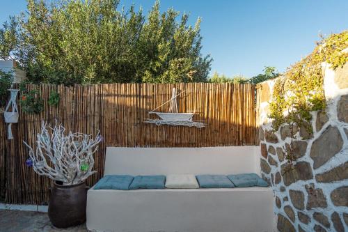 a white couch sitting in front of a fence at MANOS Small House Kouremenos in Palekastron