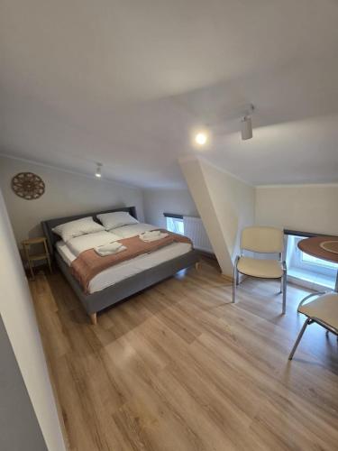 a bedroom with a bed and a table and chairs at Apartamenty Emilia 3 in Gniezno