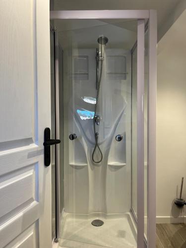 une douche avec une porte vitrée dans une salle de bain dans l'établissement Maison rivage bleu 4 pers 2 sdb clim wifi, à Gruissan