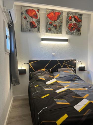 - une chambre avec un lit et une couette noire et jaune dans l'établissement Maison rivage bleu 4 pers 2 sdb clim wifi, à Gruissan