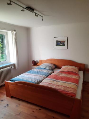 ein Bett in einem Schlafzimmer mit Holzrahmen in der Unterkunft Ferienwohnung Gieske - Wollmann in Westerholz