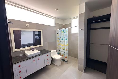 une salle de bain avec un lavabo, des toilettes et un miroir dans l'établissement Hermosa casa con vista al mar en Jama Campay, à Los Camarones